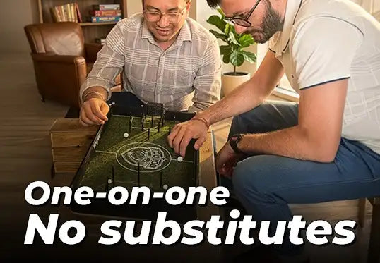 Two men playing Toujoo Football club Tabletop game together in a cozy living room.